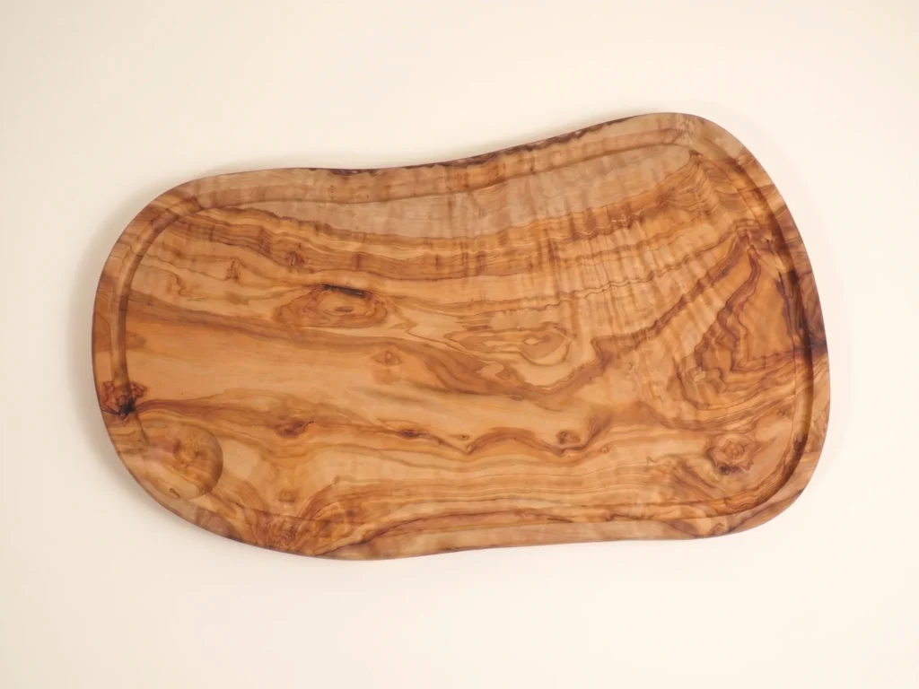 Olive wood board in an overhead ecommerce view on an ivory background