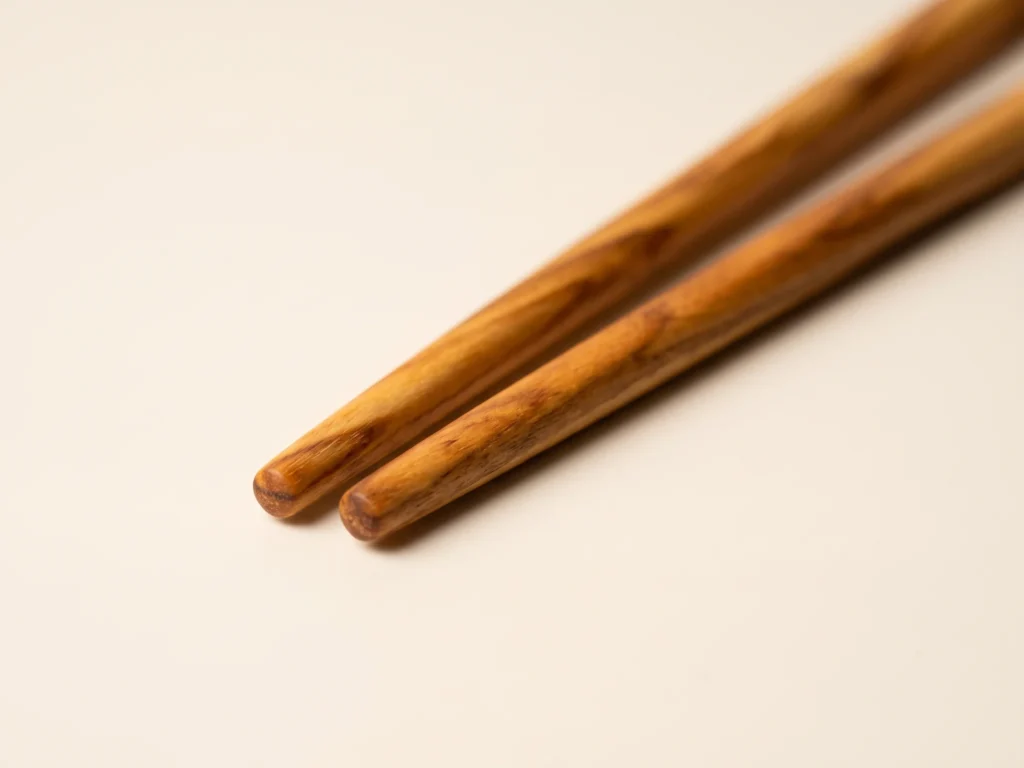 Gros plan macro sur les pointes effilées arrondies et le veinage de fil de la paire de baguettes SC-9