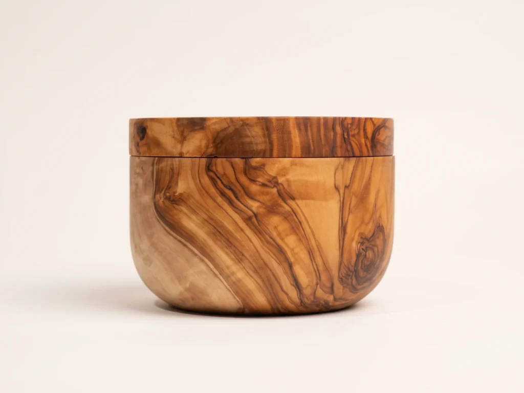 Low profile side view of the olive wood salt keeper showing cylindrical height and horizontal hairline lid seam