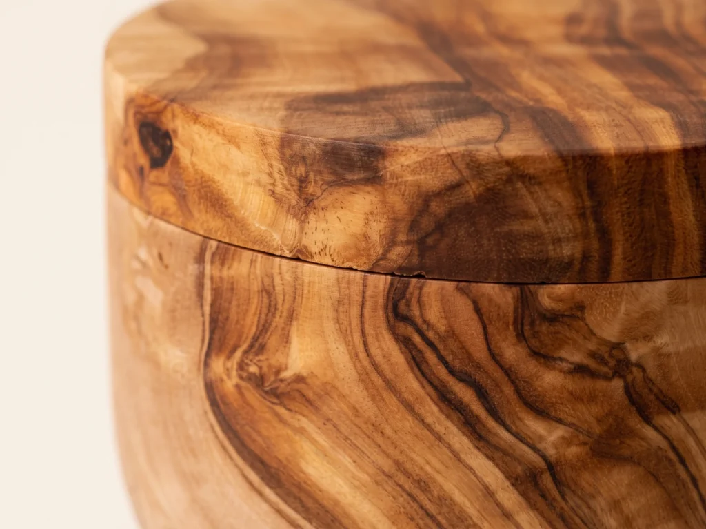 Macro close-up of the olive wood salt keeper showing the tight wood-to-wood lid fit and dense grain texture