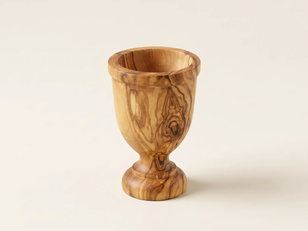Olive wood egg cup TR-22 three-quarter perspective on neutral light background showing turned pedestal and chalice
