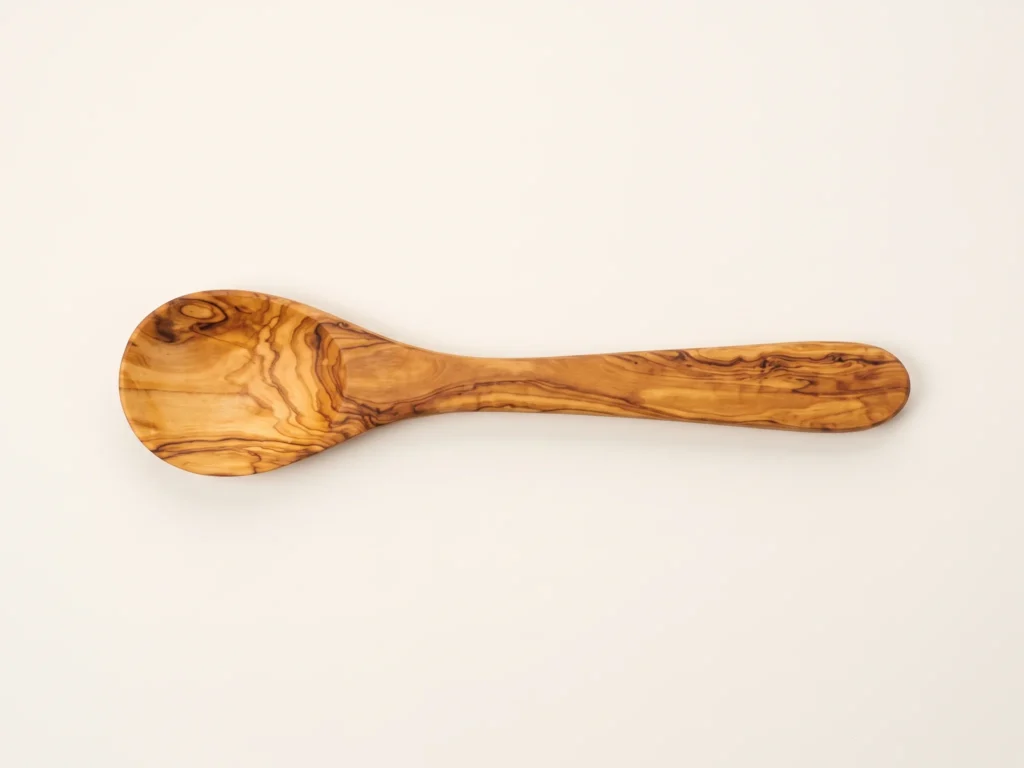 Overhead 90-degree knolling flat-lay photograph of olive wood flat shape spoon showing grain patterns