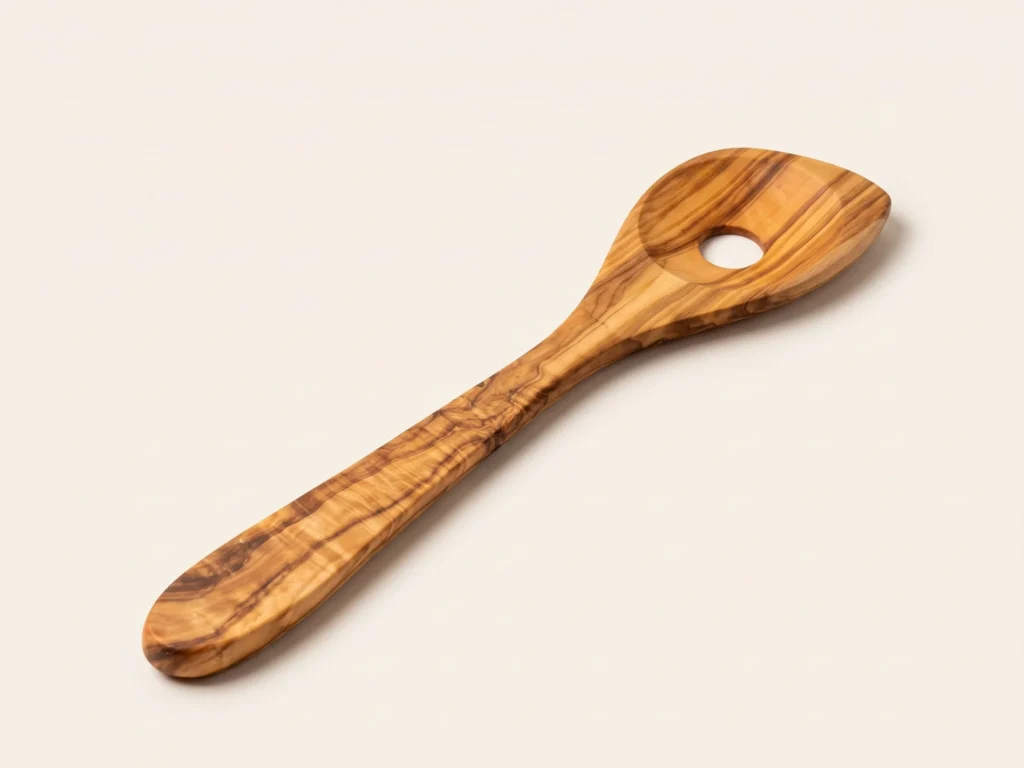 Cuillère avec trou en bois d'olivier MT-32 vue perspective basse sur fond ivoire