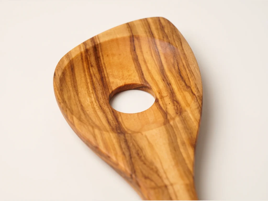 Cuillère avec trou en bois d'olivier MT-32 macro gros plan tête asymétrique et ouverture centrale