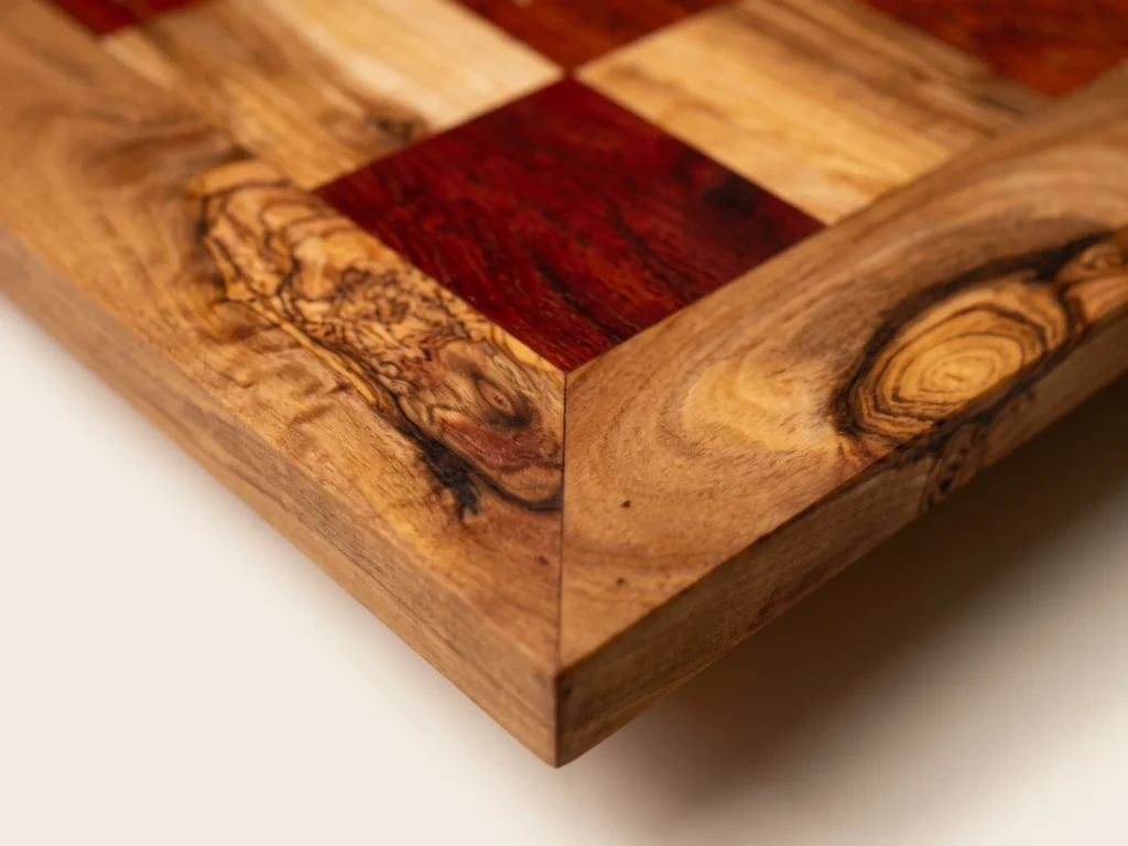 Macro close-up view of 45-degree miter corner joint with clean straight planed edge and 40 mm red contrasting squares