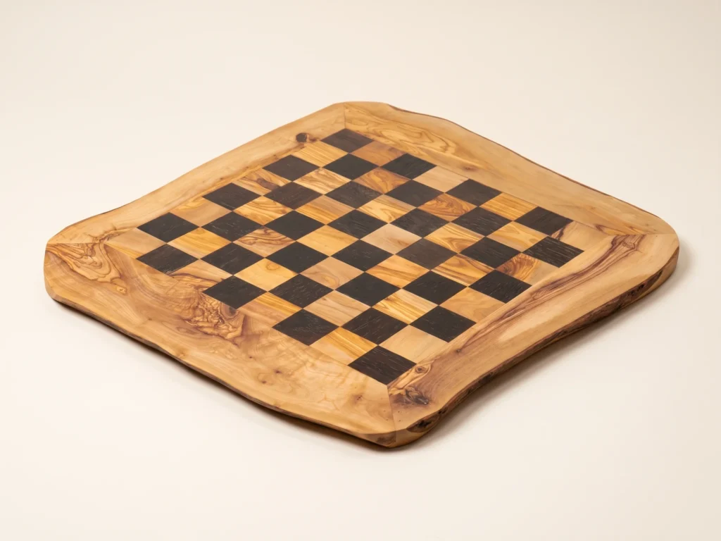 Three-quarter perspective view of rustic black olive wood chess board on ivory background