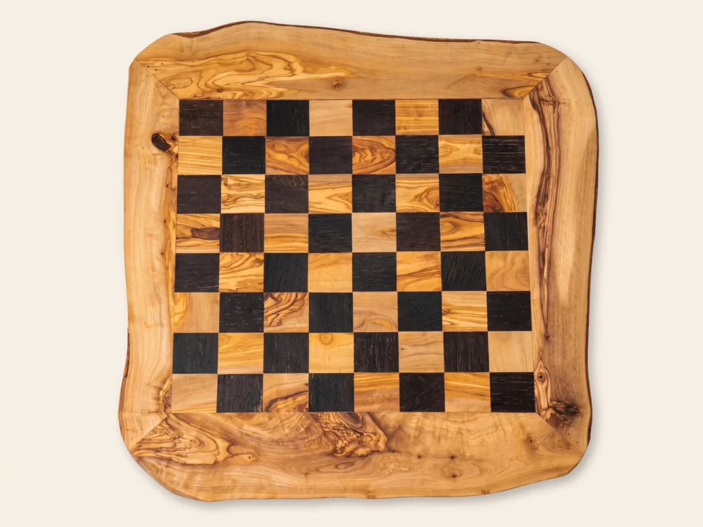 Direct 90-degree overhead flat-lay view of rustic black olive wood chess board 8x8 grid