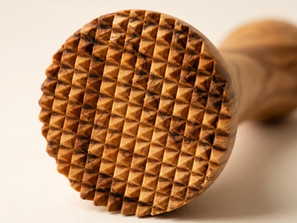 Gros plan macro detaille sur la surface de frappe a dents pyramidales et contour cisele de l attendrisseur a viande en bois d olivier