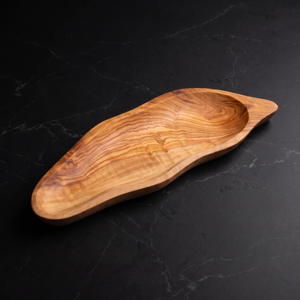 Handcrafted olive wood leaf-shaped plate with carved stem contour