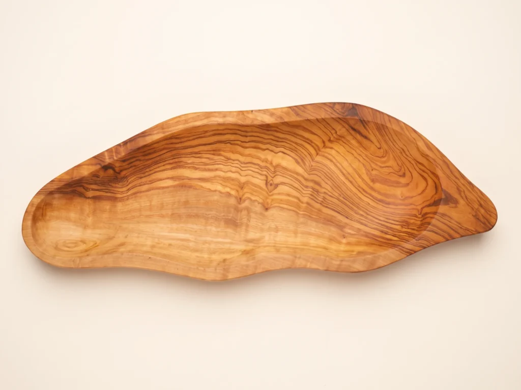 Top-down overhead view of leaf-shaped olive wood plate BL-13 displaying organic contours and wood grain