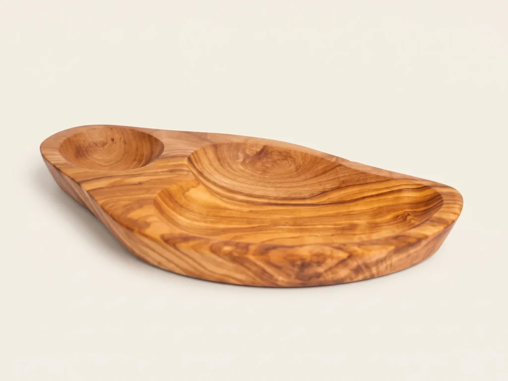 Three-quarter catalog angle of olive wood dish BL-15 showing dual compartments on warm ivory studio background