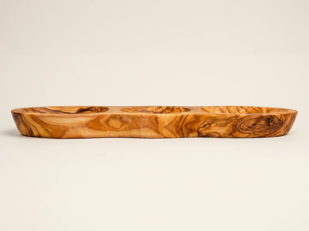 Low profile horizontal side view of olive wood appetizer platter BL-24 showing smooth carved exterior and stable base