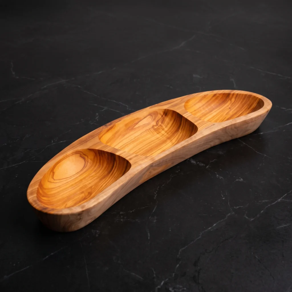 Handcrafted 3-compartment boat-shaped olive wood appetizer platter on dark marble