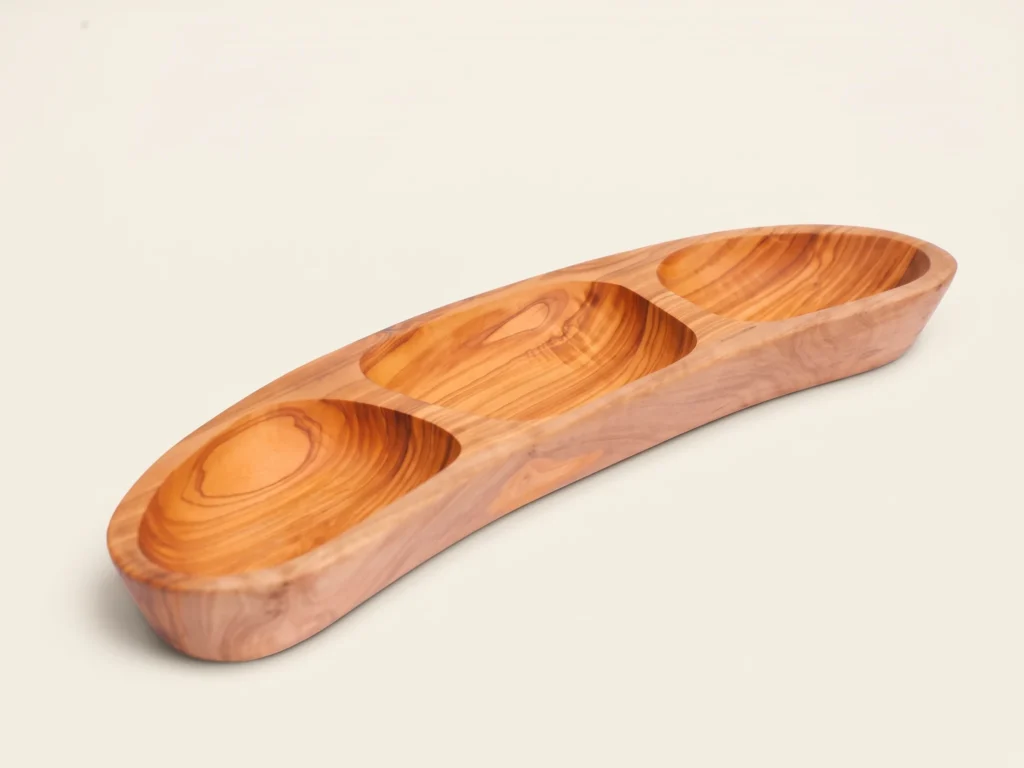 Three-quarter catalog view of 3-section boat-shaped olive wood appetizer platter BL-25 on warm ivory background