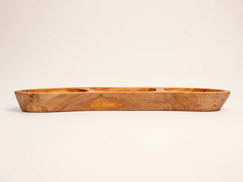 Horizontal low-profile side view of olive wood appetizer platter BL-25 showing smooth sculpted rim and stable base