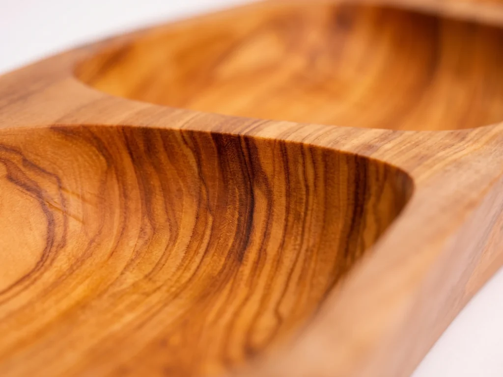 Macro close-up shot of the sculpted internal divider and contrasting olive wood heartwood grain on platter BL-25