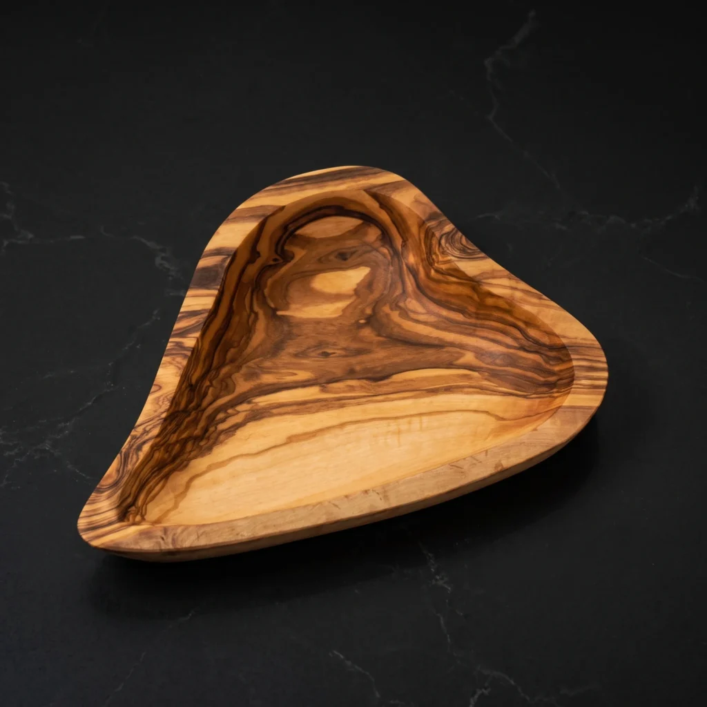 Artisanal olive wood heart-shaped dish with dramatic swirling grain