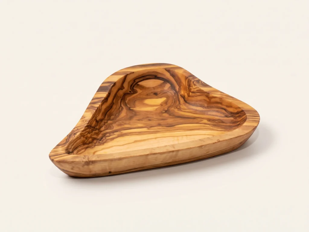 Three-quarter angle studio view of handcrafted olive wood heart dish BL-8 on neutral backdrop