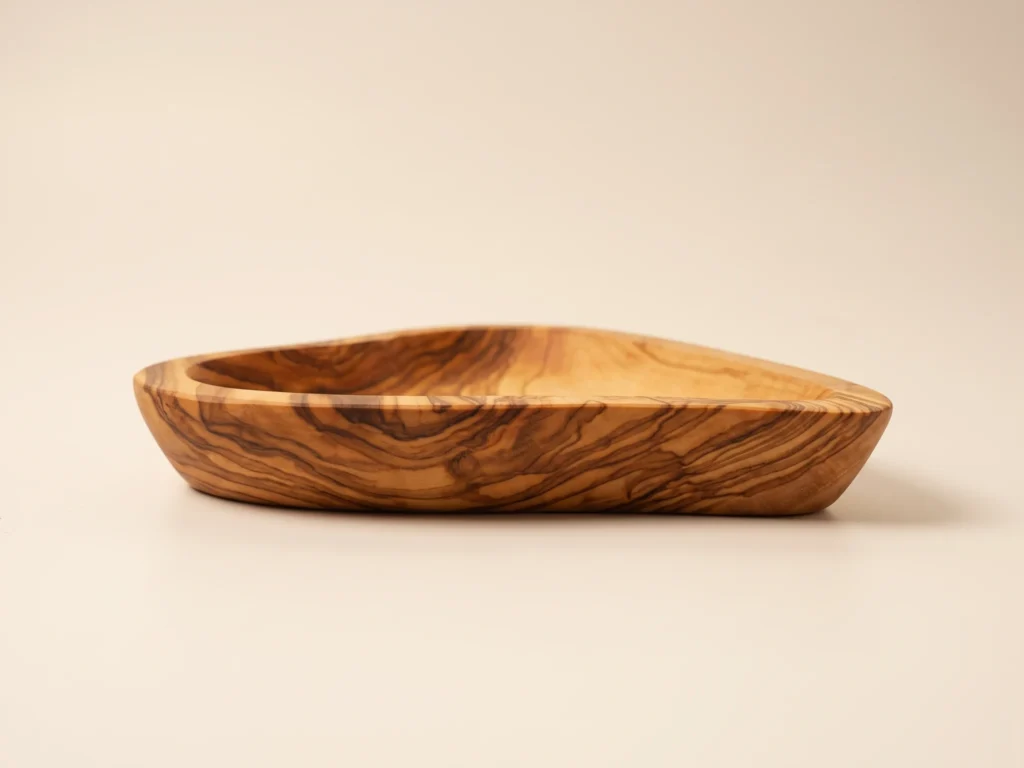 Eye-level side profile of olive wood heart dish BL-8 displaying smooth curved rim and flat stable base