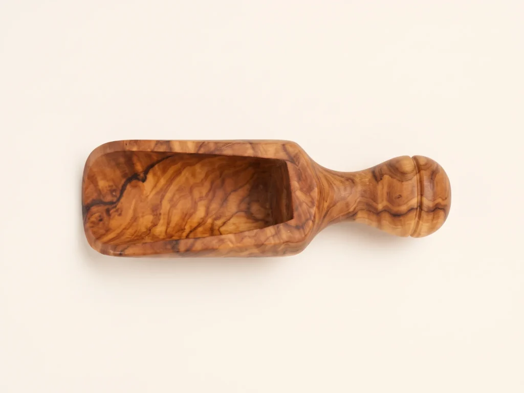 Olive wood spice scoop TR-23 direct 90-degree overhead view showing hollow trough cavity and symmetrical turned handle