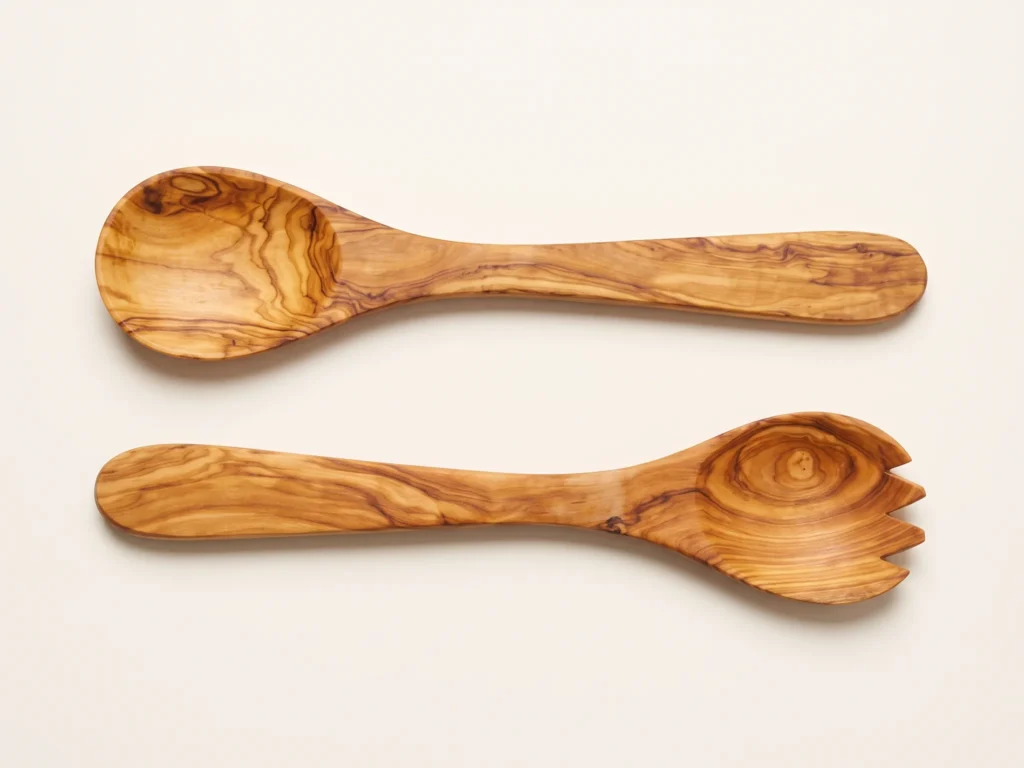 Overhead 90-degree knolling flat-lay photograph of olive wood salad server set showing grain patterns and knot