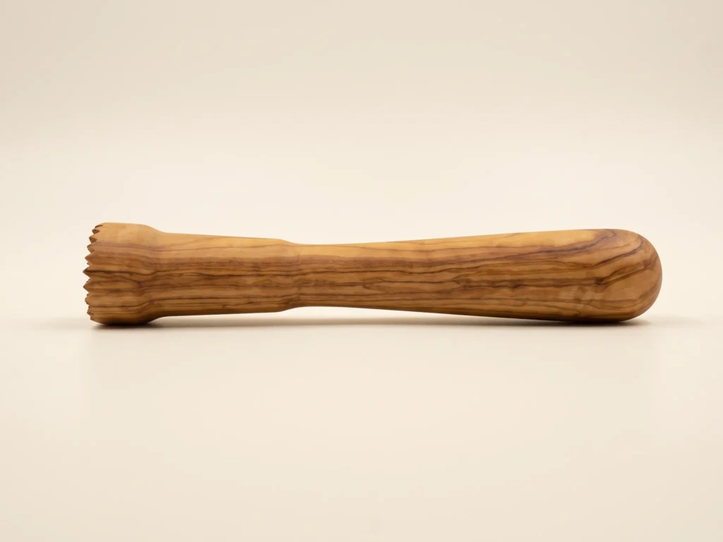 Pilon à cocktail en bois d'olivier TR-33 en vue profil rasant montrant le galbe ergonomique et le pommeau arrondi