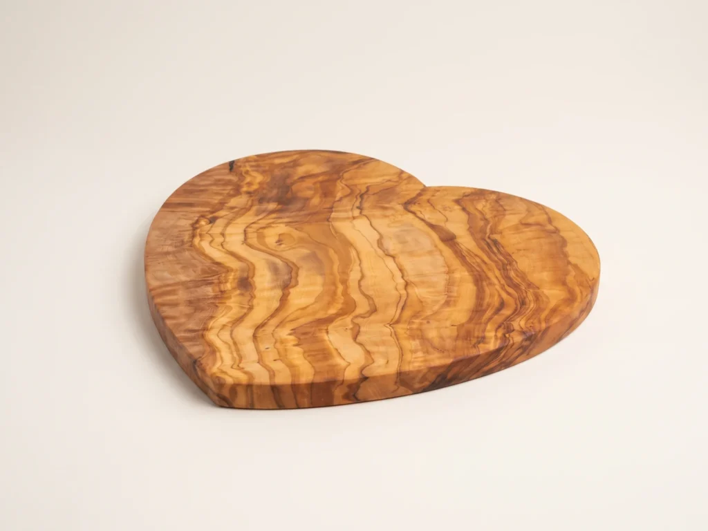 Heart-shaped olive wood cutting board low three-quarter perspective view
