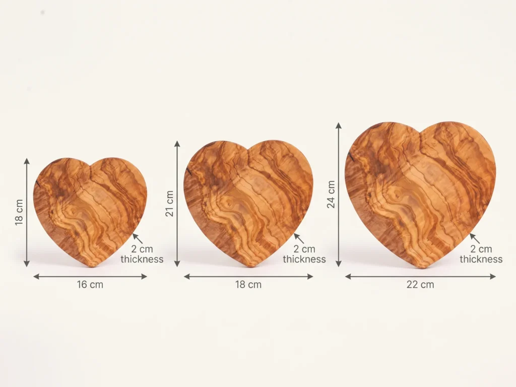 Heart-shaped olive wood cutting board size comparison showing 18x16, 21x18, and 24x22 cm with 2 cm thickness
