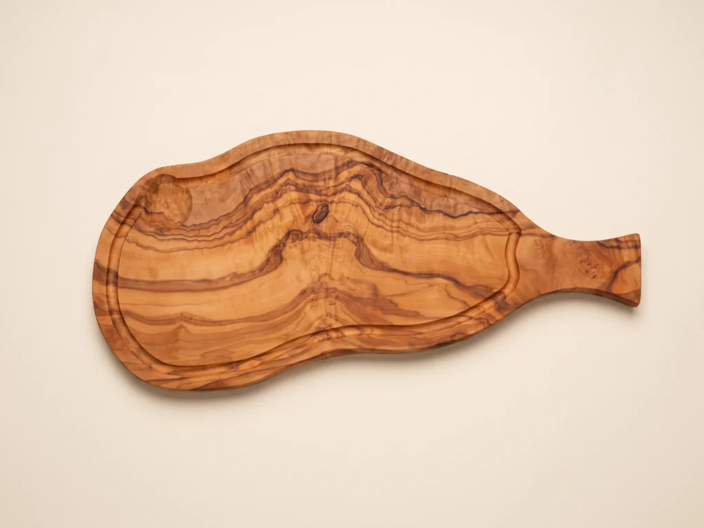 Natural shaped olive wood cutting board with juice groove and handle overhead 90-degree technical view