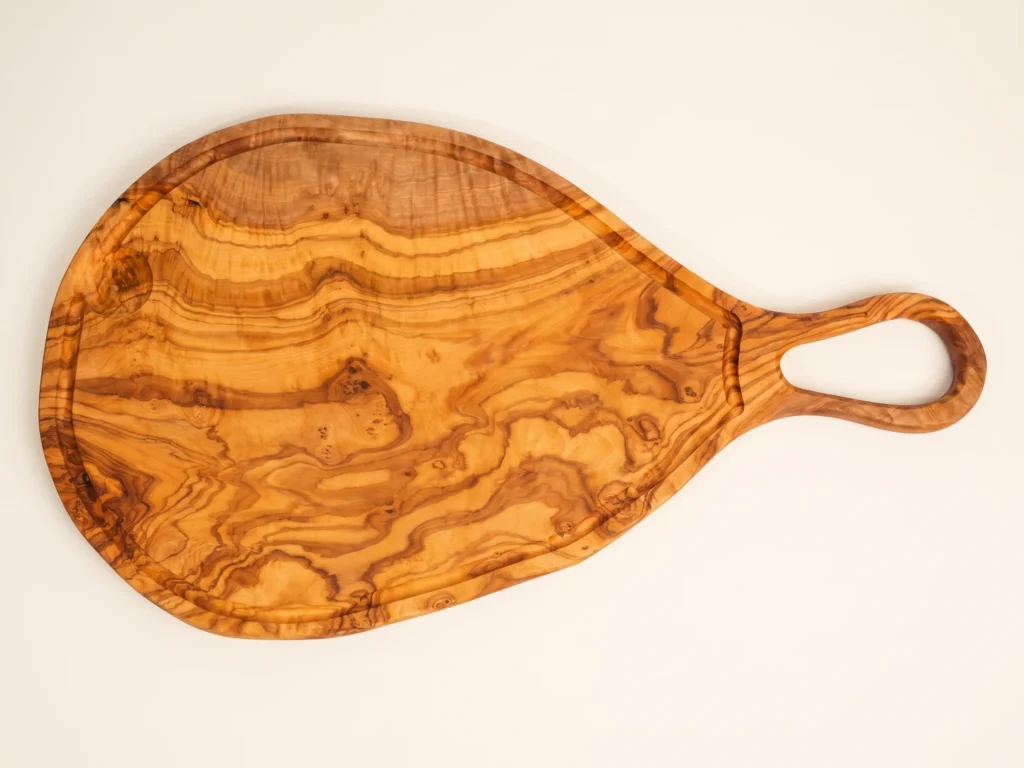 Large natural shaped olive wood cutting board with juice groove and hole overhead 90-degree technical view