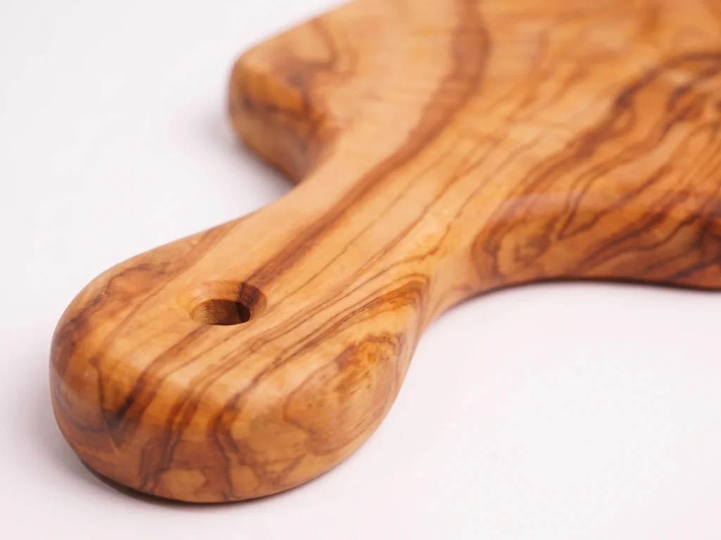 Olive wood persil board macro detail of handle and round hanging hole