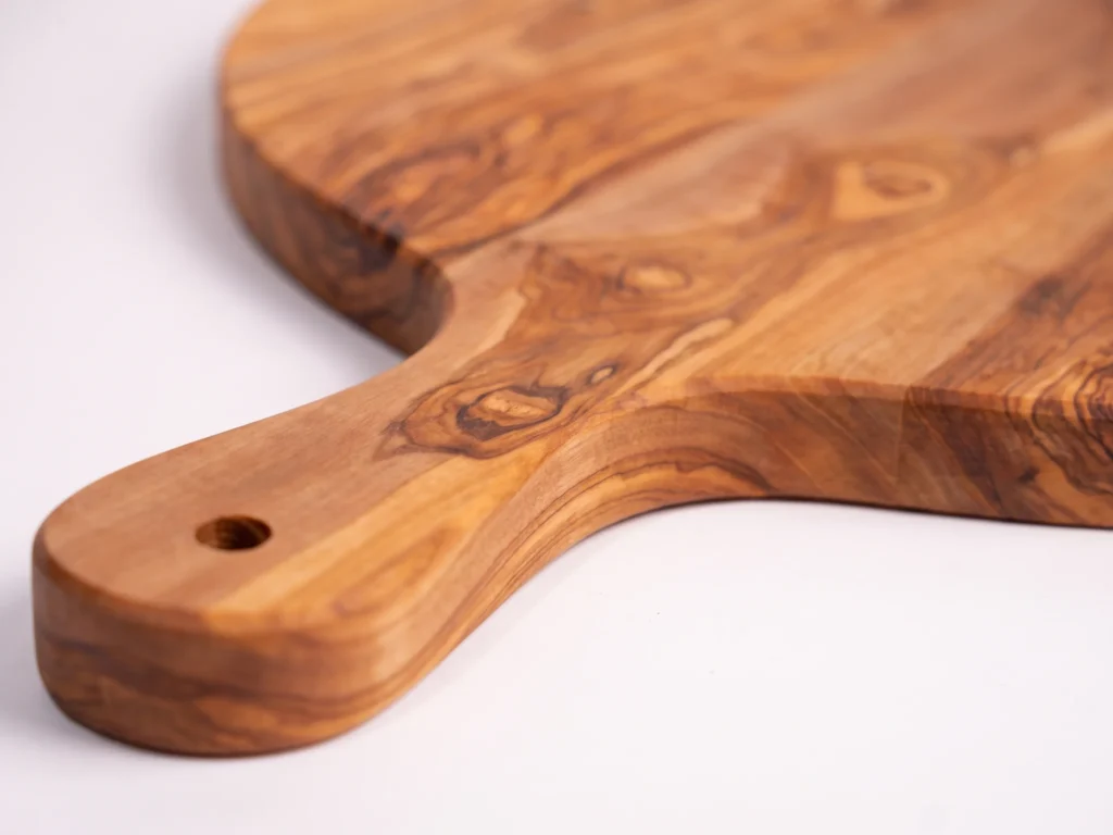 Round olive wood board with handle macro detail handle and grain