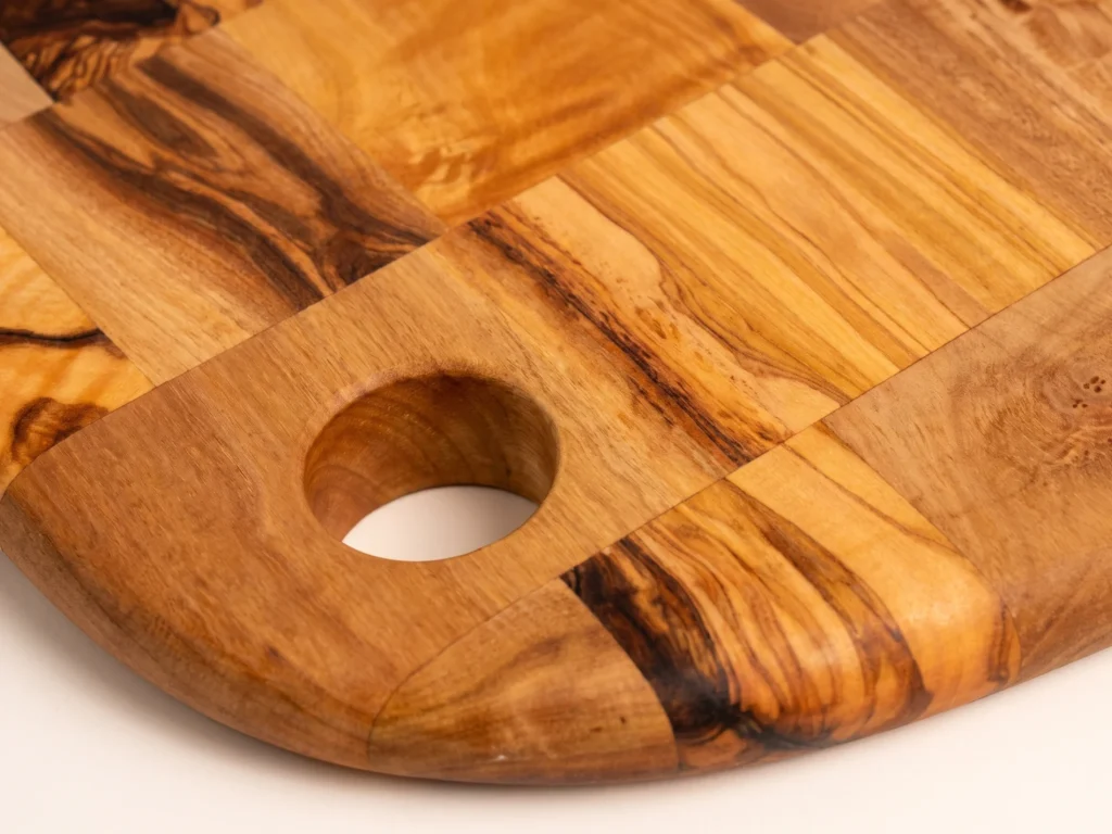 Special shape rounded olive wood cutting board macro detail hanging hole and wood grain