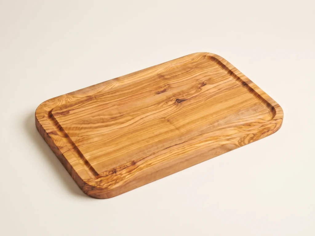 Rectangular edge-glued olive wood cutting board with rounded corners in low three-quarter view