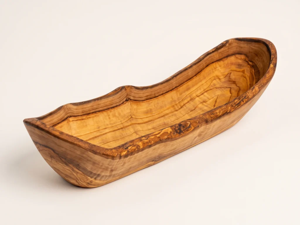 Three-quarter catalog view of rustic olive wood bread basket BL-2 on seamless warm ivory background