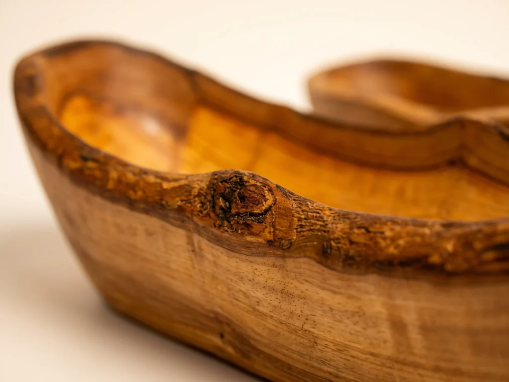 Macro close-up of natural bark rim and dense olive wood grain on rustic bread basket BL-2