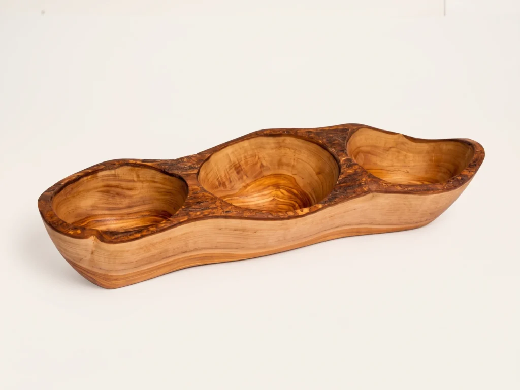 Three-quarter catalog view of rustic olive wood 3-compartment appetizer dish BL-3 on seamless warm ivory background