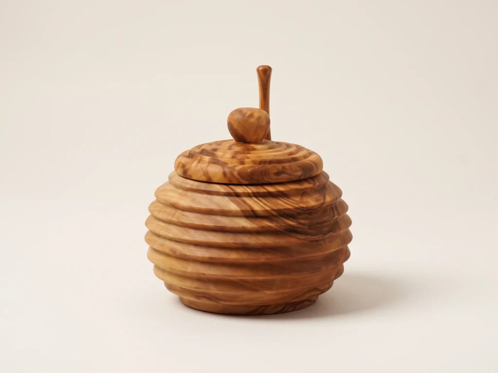 Low profile technical view of olive wood honey jar showing ribbed profile and flat base