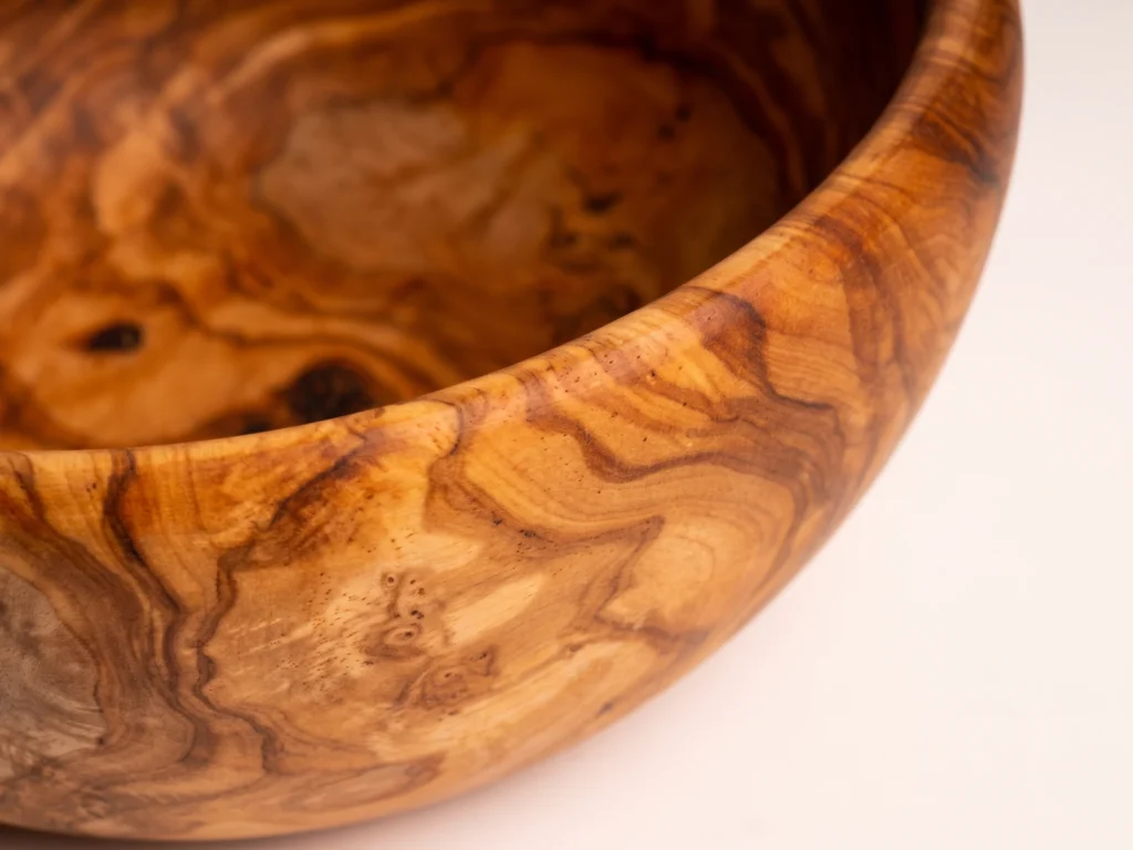 Macro close-up of smooth rim and rich wood grain on olive wood salad bowl SL-1