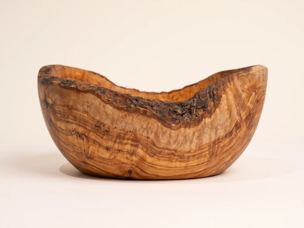 Eye-level low profile view of rustic olive wood salad bowl SL-2 showing live edge contour