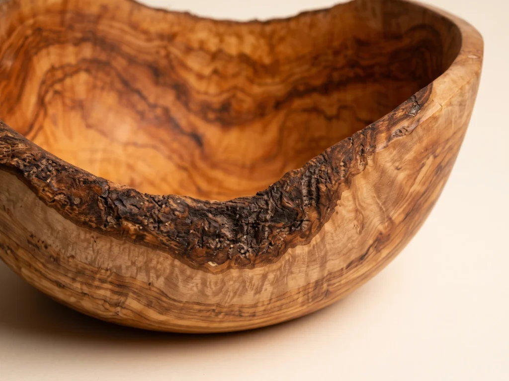 Macro close-up of natural bark rim and dense grain on rustic olive wood salad bowl SL-2