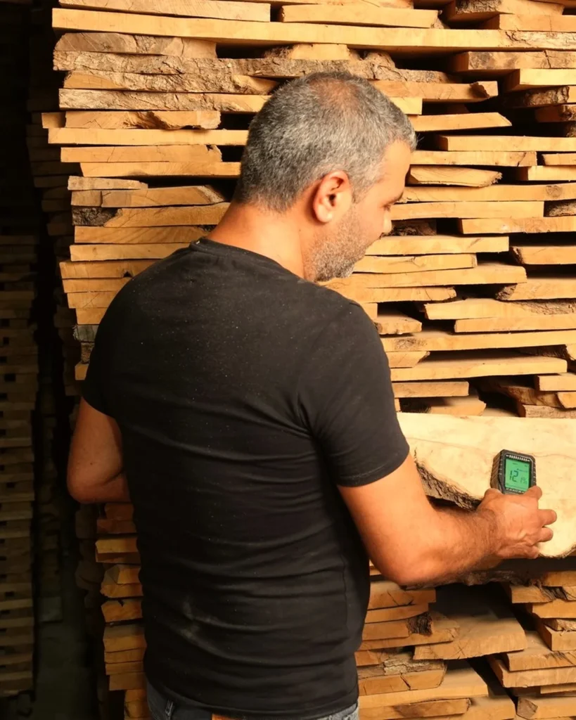 Olive wood moisture testing at 12.1% on seasoned drying lumber stacks in Olizou workshop